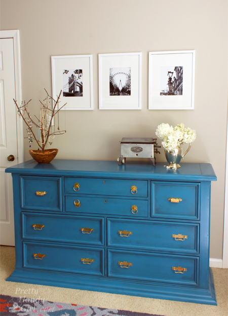 A refinished wooden sideboard left with a natural stain – not painted! Learn how to refinish this sideboard.