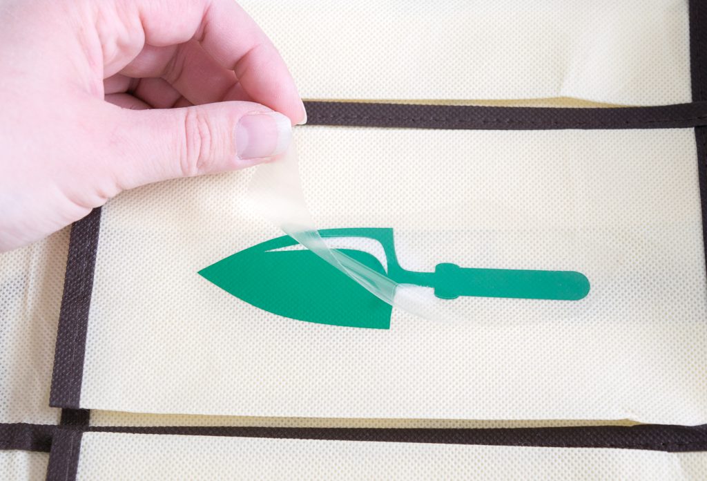 You know your design is ironed onto the fabric well when the plastic peels up easily.