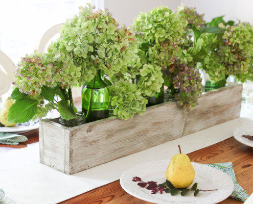 Green and purple hydrangeas in rustic wood trough. Build Your own Rustic Trough Centerpiece tutorial.