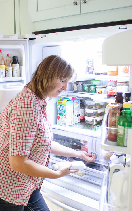 Woman replacing water filter in fridge