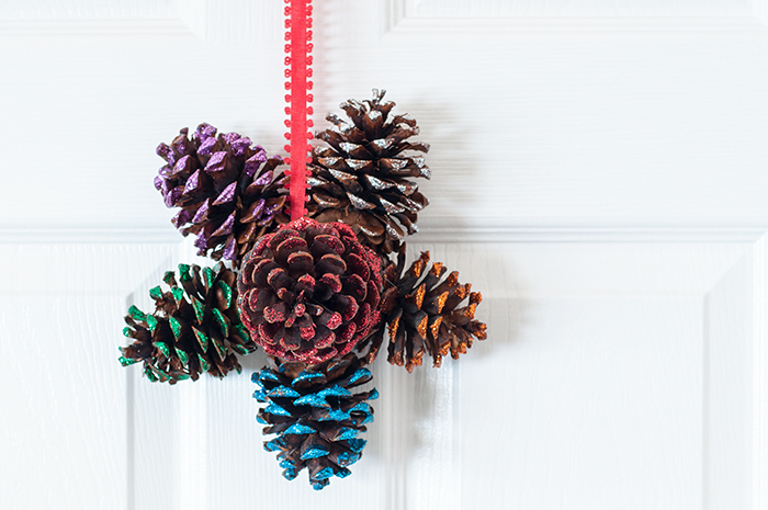 how to make a glittered pine cone door hanger