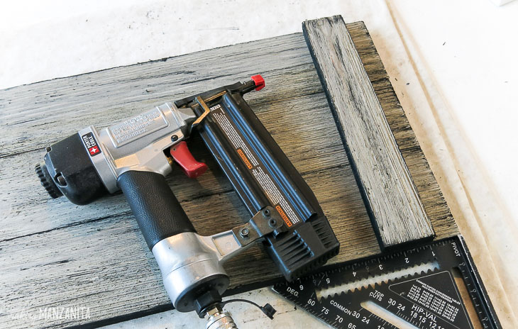brad nail gun laying on top of assembled wood tray