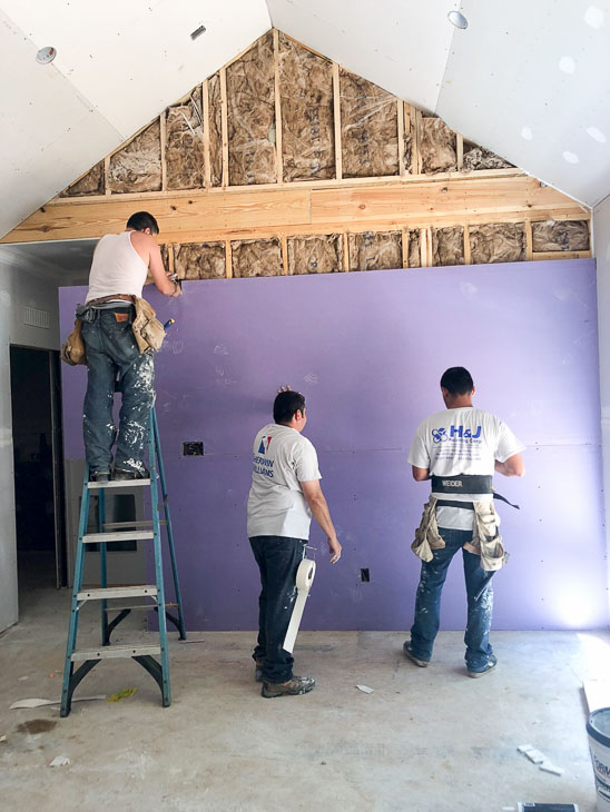three guys installing purple drywall