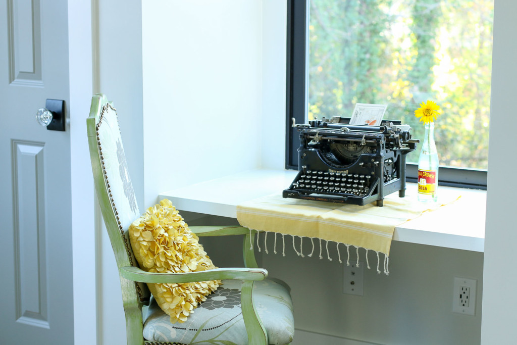 vintage typewriter on desk by window between closets