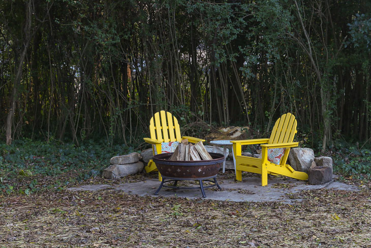 adirondack chairs around fire pit on old shed concrete pad