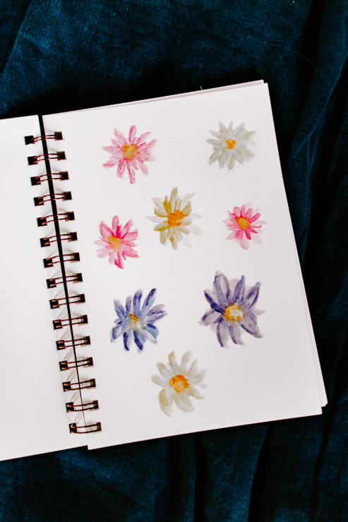 a page of yellow, purple and pink watercolor flowers
